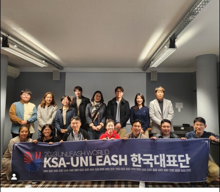 2023 UNLEASH WORLD 한국대표단 현수막을 들고 단체 기념 촬영하는 참가자들